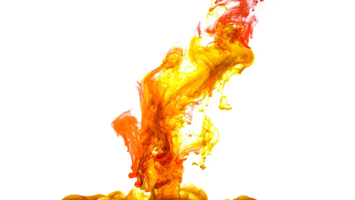 Dynamic blend of bright red and yellow ink swirling in water creating a fiery abstract design.